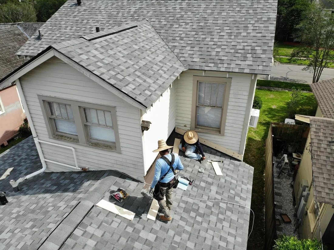 Two Mid City crew members working on a residential roof repair